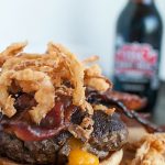 cheddar stuffed burger with onion strings and candied bacon
